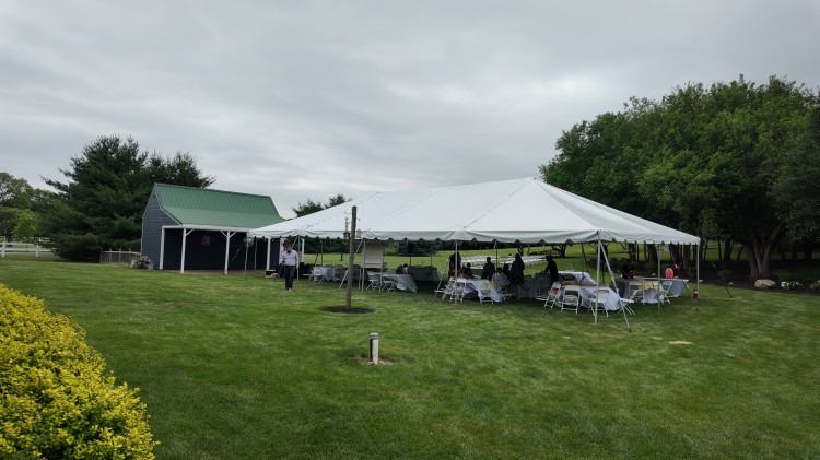 Large frame tent set up on pavement in central Indiana